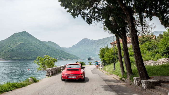 Porsche 964 Carrera 4 rouge longeant un lac