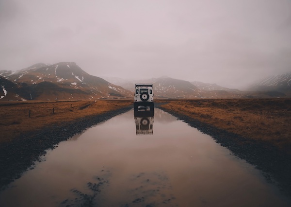 Land Rover Defender blanc sur une route inondée