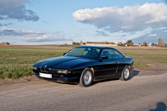 BMW 840 noire de 3/4 face dans un champ