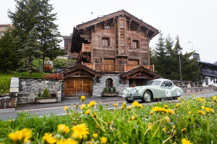 Jaguar XK 120 Coupe verte devant un chalet