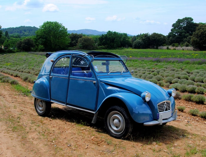 Citroën 2CV bleue de 3/4 face dans un champ