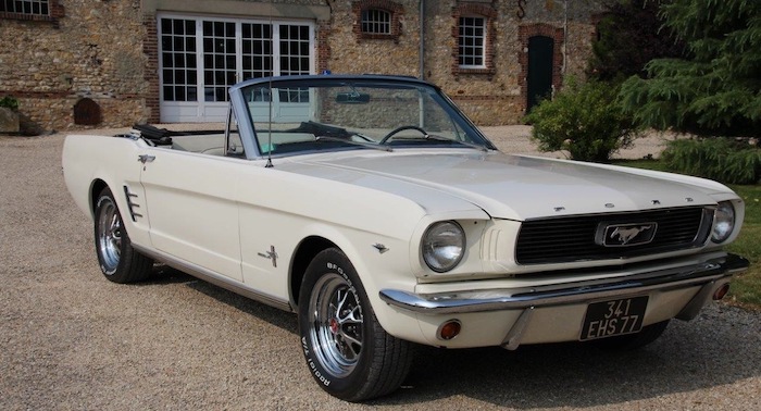 Ford Mustang de 1966 blanche devant une maison de campagne