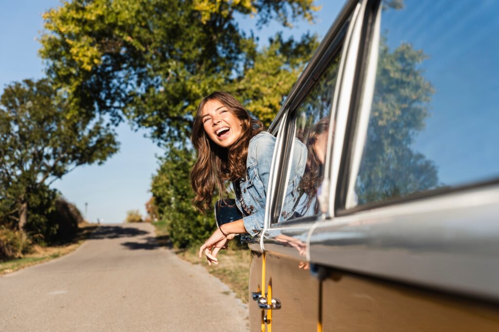 Pretty woman on a road trip with her camper, looking out of car window