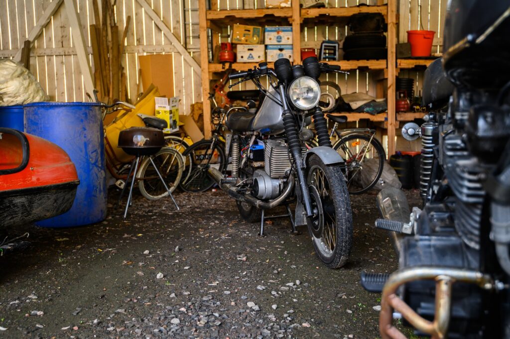 10.10.2019 Helsinki, Finland - open garage space, with vintage motorcycle in storage on shelving.