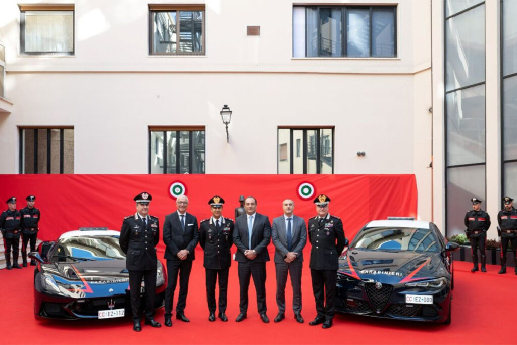 les carabinieri italiens qui posent aux ootés de deux voitures : alfa romeo et maserati