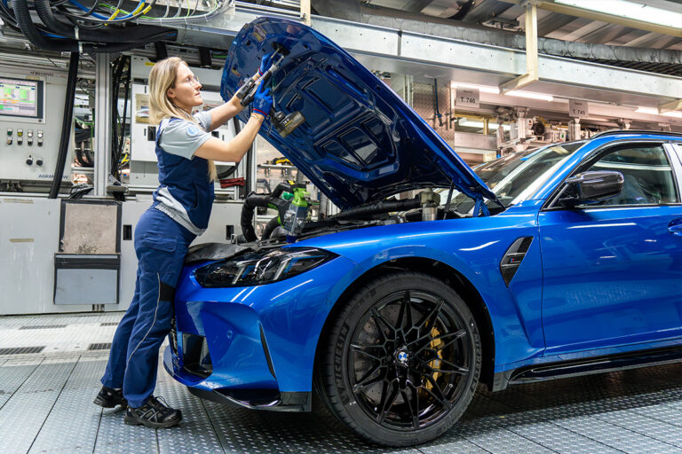 Une dame entrain de travailler sur une BMW sur la ligne d'assemblage
